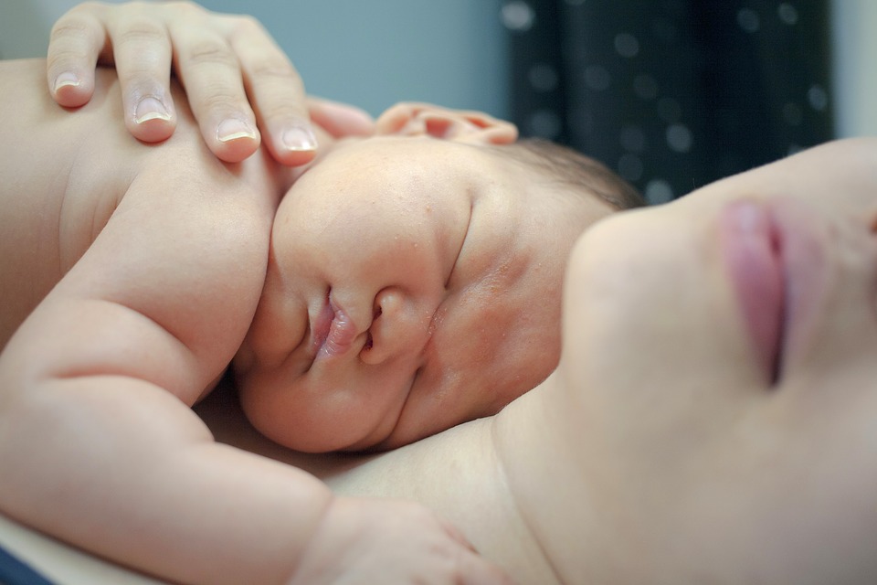 bebe enciam del pecho de la madre